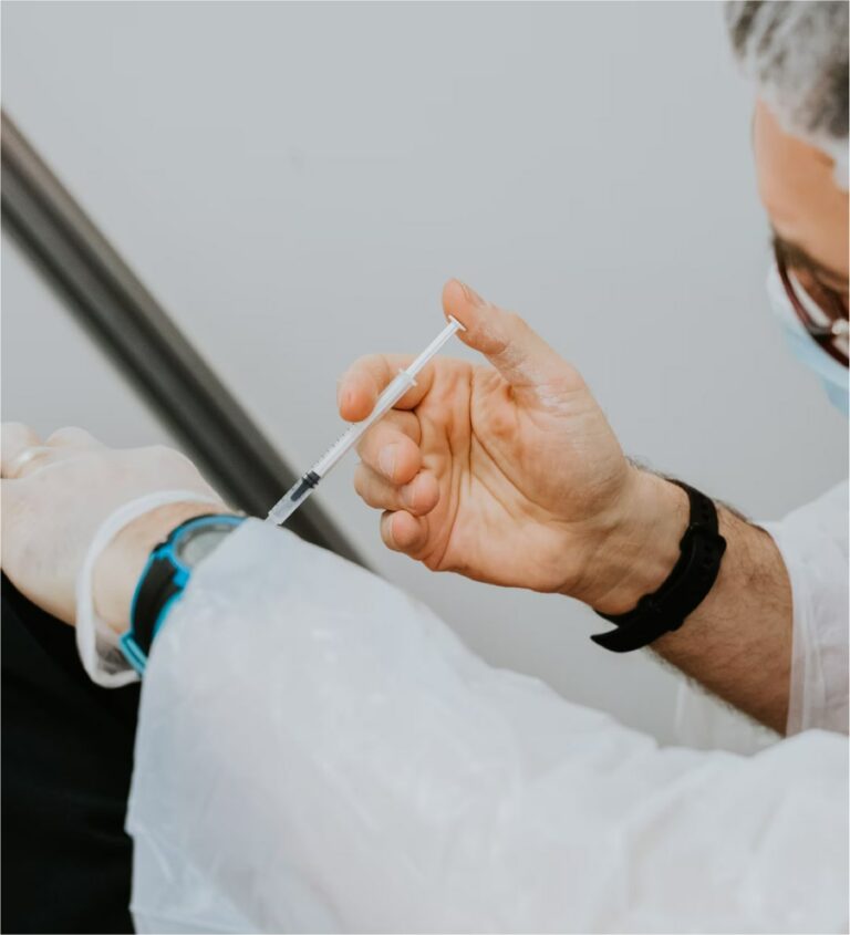 Nurse administering covid-19 vaccination, close-up of the syringe