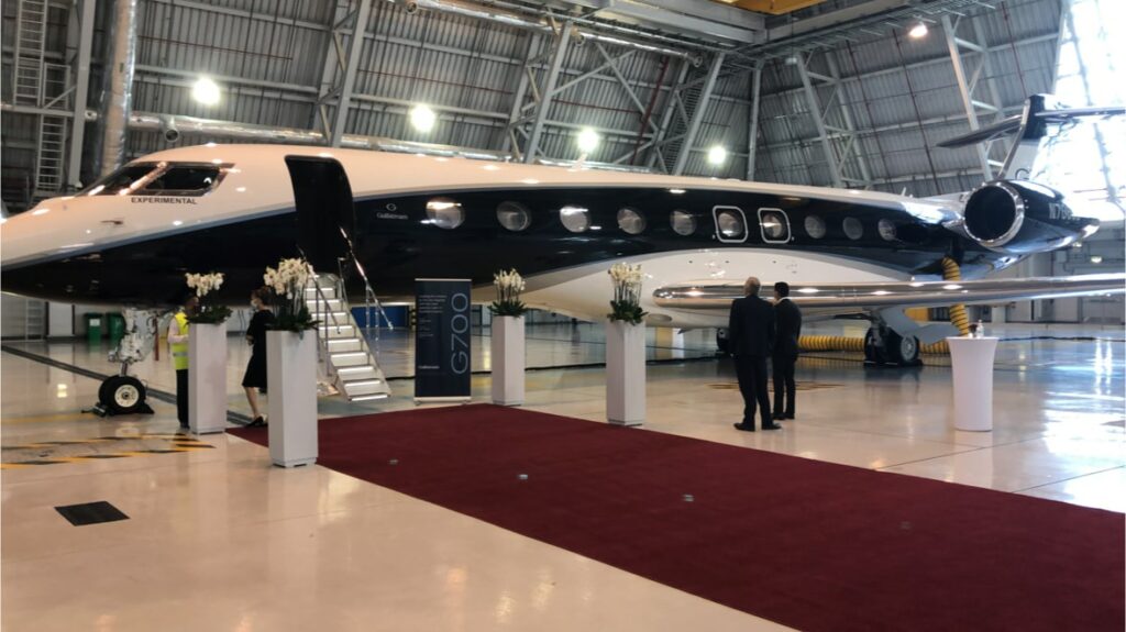 Gulstream private jet in hanger with red carpet and stairs leading up to door