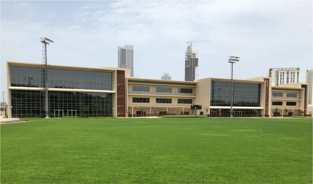Exterior of the American School of Dubai with gras field in the foreground