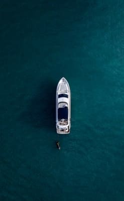 Overhead view of a motor yacht surrounded by turquoise blue sea waters.