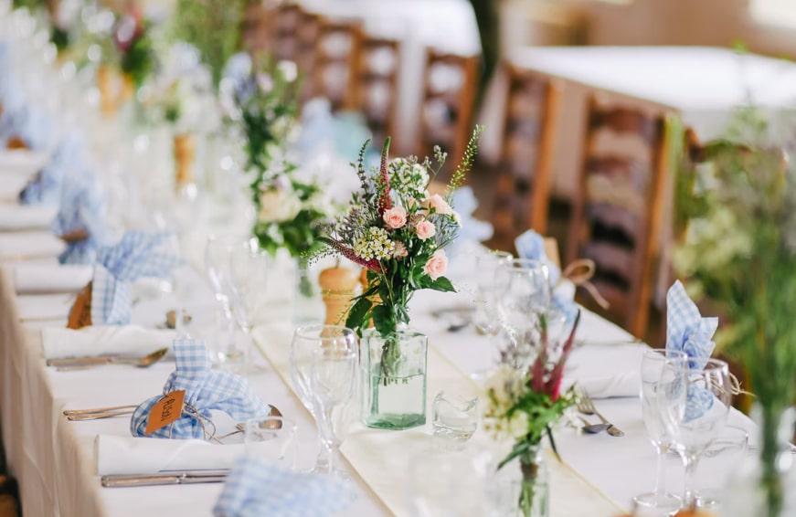table setting with flowers and gifts for an event