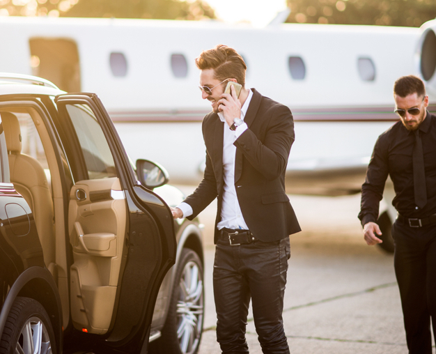 Security escorting a celebrity from private jet to limousine at the airport.